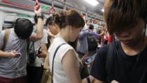 Chinos mirando sus teléfonos en el metro