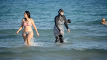 Dos mujeres en una playa francesa, una de ellas con burkini.