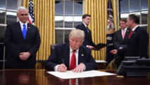 Trump firmando su primer decreto limitando la reforma sanitaria de Obama