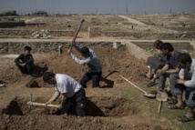 Familiares y amigos cavan la tumba de dos civiles muertos en Mosul