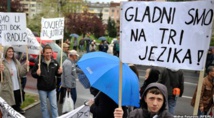 Manifestantes bosnios con los carteles donde se lee "tenemos hambre en tres idiomas"