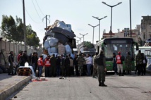 Milicianos y sus familiares saliendo de la ciudad de Homs