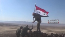 Unos soldados ponen la bandera siria. Unos soldados ponen la bandera siria.