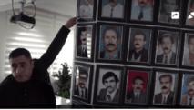 Un exprofesor señala fotos de profesores que fueron supuestamente asesinados por el estado turco. Un exprofesor señala fotos de profesores que fueron supuestamente asesinados por el estado turco.