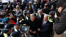 El cardenal Pell al llegar al juzgado, rodeado de policías y periodistas.