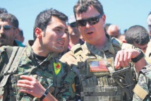 Un miliciano kurdo-a la izquierda-y un militar estadounidense. Un miliciano kurdo-a la izquierda-y un militar estadounidense.