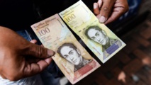 El billete de cien bolívares al lado del de cien mil bolívares