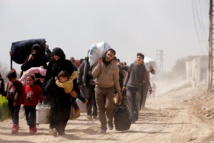 Civiles sirios salen de Hammuria, en la Guta Oriental de Damasco.