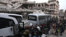 Familiares de milicianos subiendo a los autobuses que los llevarán al norte de Siria, en la Guta Oriental de Damasco.