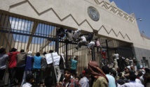 Manifestantes escalando la valla de la embajada de Estados Unidos en Saná, Yemen.