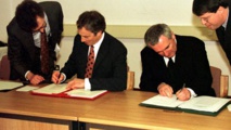El primer ministro británico, Blair-a la izquierda-y el primer ministro irlandés Ahern firman los acuerdos de paz en 1998.