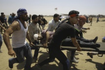 Palestinos llevan en Gaza a un herido por las balas de los soldados israelíes