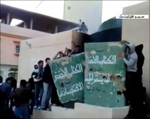 Manifestantes golpean una representación del libro verde de Gadafi, en Bengasi, Libia.