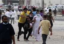 Los manifestantes evacúan a un afectado por los gases lacrimógenos en Manama, Bahrein.