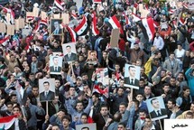 Manifestantes partidarios del régimen del Baaz llevan fotos del presidente Bashar Al Asad, en Homs, Siria.