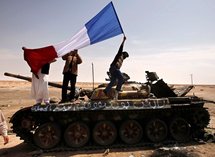 Rebeldes libios ondean una bandera francesa sobre un tanque abandonado, en Ajdabia, Libia.