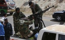 Rebeldes libios disparan una ametralladora desde un camión en las afueras de Brega, Libia.