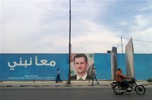 Un hombre pasa ante un cartel en Damasco, Siria.