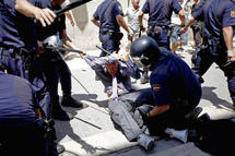 La policía golpea a un manifestante, en Valencia.