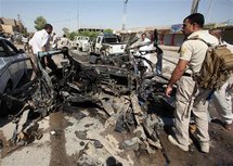 Policías inspeccionan el lugar donde explotó un coche bomba en Nayaf, Irak.