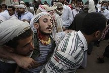 Manifestantes transportan a un herido en Saná, Yemen.
