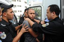 Policías detienen a uno de los manifestantes en Túnez.