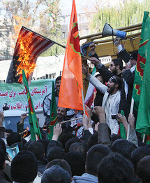 Manifestantes queman una bandera estadounidense en Irán.