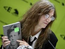 Patti Smith, sosteniendo un libro de Rimbaud.