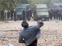 Un manifestante lanza una piedra a los policías. Un manifestante lanza una piedra a los policías.