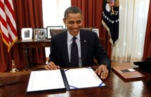 Barak Obama firma la ley aprobada.