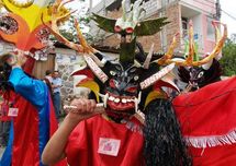 Ángeles rebeldes con cuernos y colmillos danzan en fiesta de Ecuador