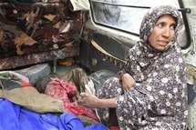 La abuela de uno de los niños asesinados, junto a los cadáveres.