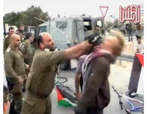 Un oficial del ejército israelí golpea a un manifestante europeo con un M-16. Un oficial del ejército israelí golpea a un manifestante europeo con un M-16.
