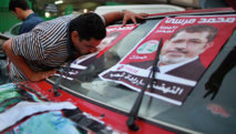 Un egipcio besa una foto de Muhammad Mursi. Un egipcio besa una foto de Muhammad Mursi.
