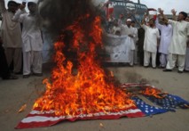 Manifestantes contrarios al film queman una bandera estadounidense