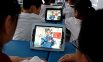 Niños chinos miran a la astronauta en la estación espacial china.
