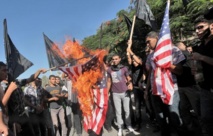 Manifestantes quemando banderas estadounidenses en protesta por el film