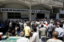 La gente mira el nuevo banco abierto por el gobierno de Hamas en Gaza La gente mira el nuevo banco abierto por el gobierno de Hamas en Gaza