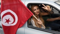 Una tunecina con la bandera de su país Una tunecina con la bandera de su país