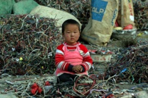 Un niño chino rodeado de residuos