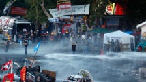 La policiá dispersando a manifestantes con chorros de agua durante las protestas del año pasado