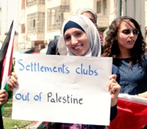 Una manifestante palestina pide la expulsión de los clubes de futbol de las colonias de Cisjordania