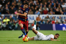El uruguayo Luis Suárez, del Barcelona, de pie, supera al brasileño Danilo, del Madrid, en el suelo.