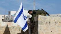 Un soldado israelí retira la bandera israelí en Hebrón Un soldado israelí retira la bandera israelí en Hebrón