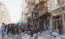 La gente ante un edificio bombardeado en Alepo.