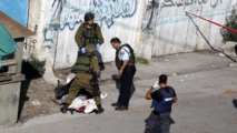 Soldados israelíes ante un palestino muerto Soldados israelíes ante un palestino muerto