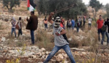 Un jóven palestino lanza piedras a los israelíes Un jóven palestino lanza piedras a los israelíes