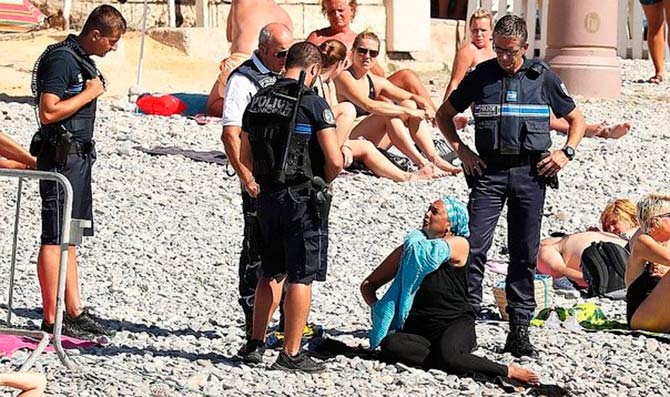 Policías multando a una mujer por llevar burkini en Niza Policías multando a una mujer por llevar burkini en Niza