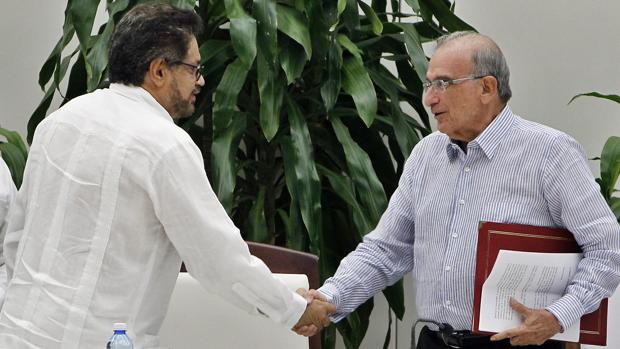 El jefe negociador de las FARC, Iván Márquez-a la izquierda-estrecha la mano al jefe negociador del gobierno Humberto de la Calle