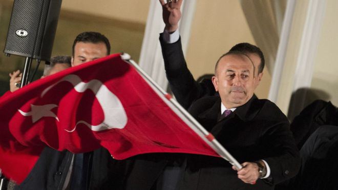 Cavusoglu con una bandera turca